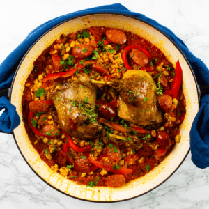 Two duck legs on top of paella with chorizo